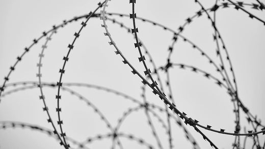 Gefängnis mit Häftlingen und Stacheldraht
